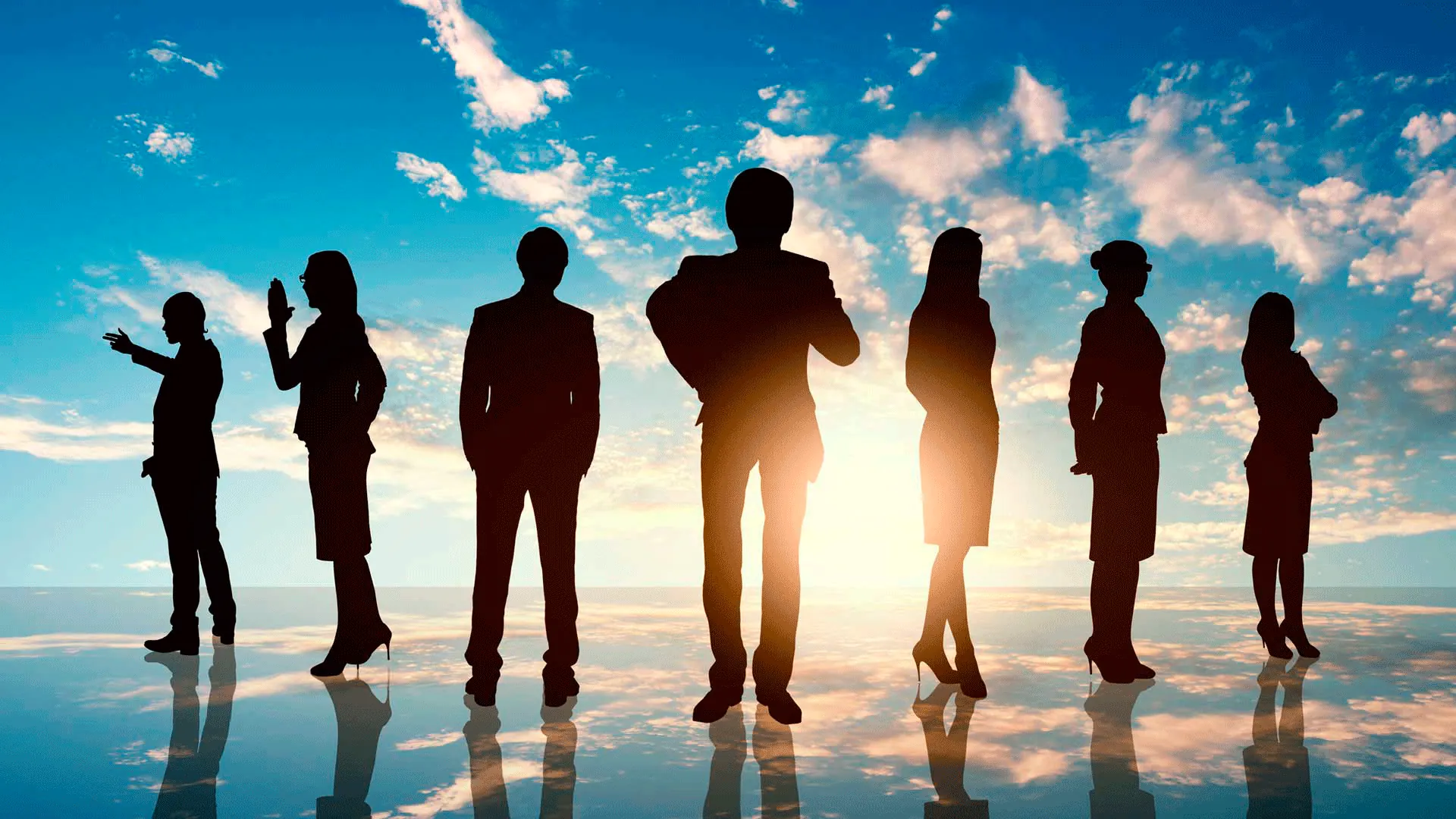 Silhouetten einer Gruppe von Menschen vor weitem Himmel