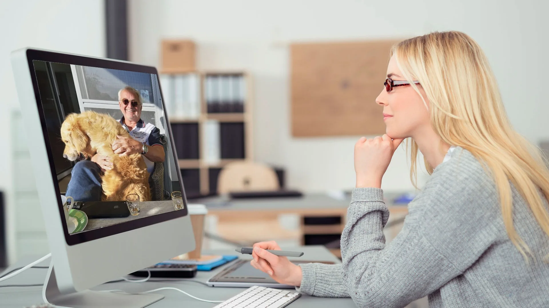 Eine Grafikerin betrachtet am Bildschirm ein Foto von Werner Herzog mit seinem Golden Retriever