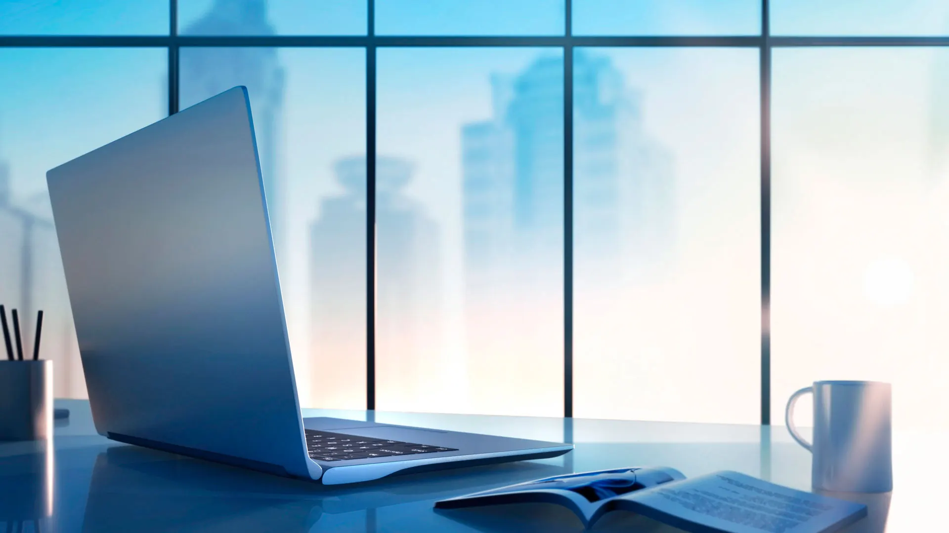 Ein Laptop auf einem Schreibtisch vor einer Glasfassade mit Skyline